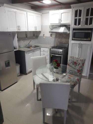 PantojaNido de Amor的厨房配有白色橱柜和桌椅