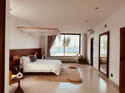 普拉伊拉多比莱尼Villa Luasah的一间卧室设有一张床和一个大窗户