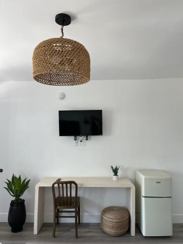 安纳海姆阿纳海姆梅因盖特汽车旅馆的客房设有带椅子的白色书桌和电视。