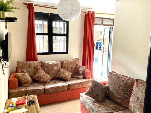 恩德培OKRA HOUSE的带沙发和红色窗帘的客厅