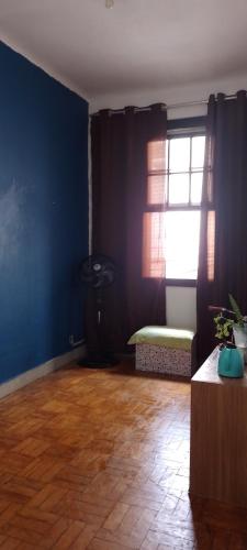 圣保罗Rafa's hostel的客厅设有蓝色的墙壁和窗户。