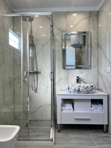 费里Hotel MoonLight的带淋浴、盥洗盆和镜子的浴室