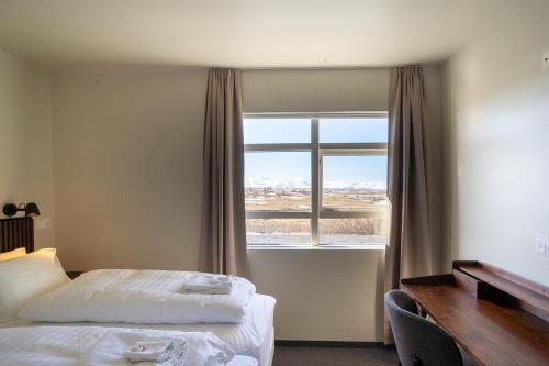 GarðurSkulagardur Country Hotel的酒店客房设有两张床和窗户。