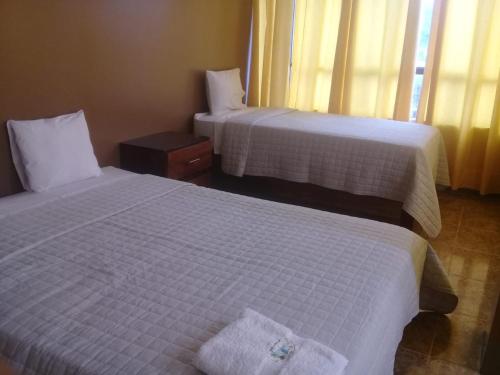 PichanakiConfort pichanaki的配有白色床单的酒店客房内的两张床
