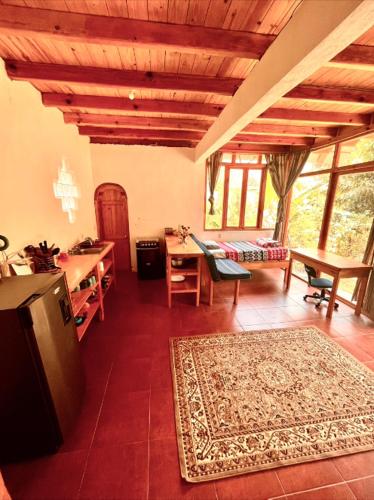 TzununáBeautiful Cabin at Gaia Temple的客厅配有书桌和一张带地毯的桌子。