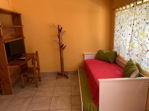埃博森Camping El Bolsón的一间配有沙发、电视和书桌的客房