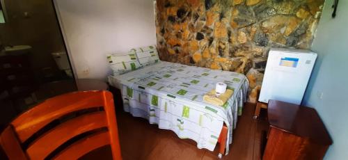 PichanakiConfort pichanaki的一间小卧室,配有一张床和石墙