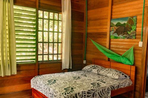 Puerto NariñoCabañas Dechi的卧室配有一张床铺,位于带木墙的房间内