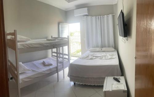 北茹阿泽鲁Hotel Shalom的客房设有两张双层床和电视。