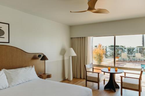 拉古纳海滩Casa Loma Beach Hotel的酒店客房,配有一张床和一张桌子及椅子