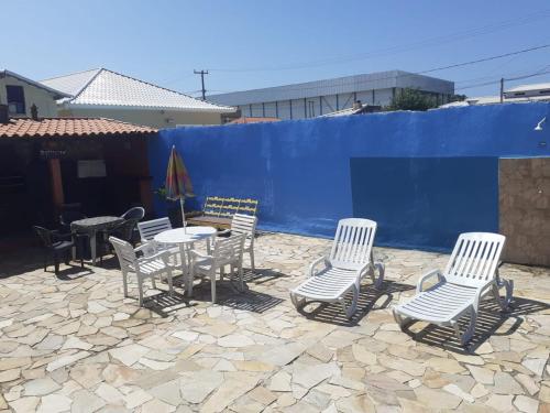 萨夸雷马Excelente casa em Saquarema a 100 passos do mar的庭院里的一组椅子和一张桌子