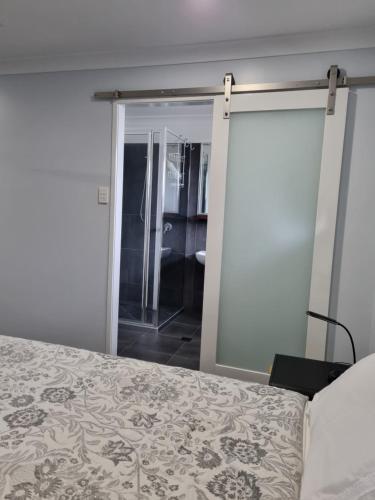 金格罗伊Banksia Villa's Kingaroy的一间卧室设有一张床和一个滑动玻璃门