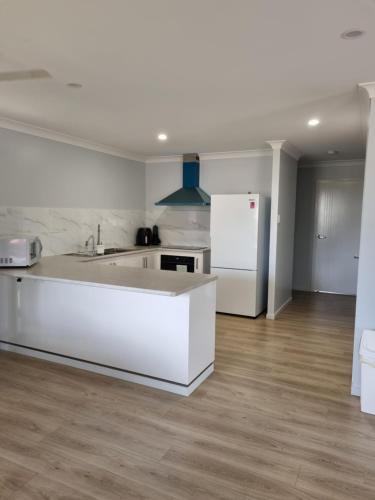 金格罗伊Banksia Villa's Kingaroy的白色的厨房配有水槽和冰箱