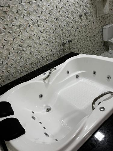 新利马Pousada Rota dos Macacos的浴室设有白色浴缸,铺着瓷砖。