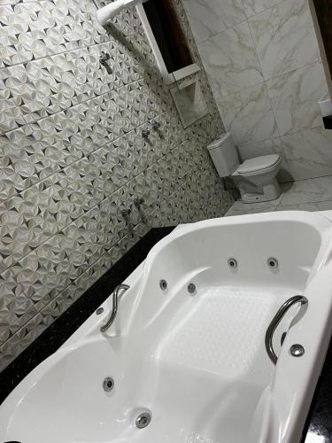 新利马Pousada Rota dos Macacos的带白色浴缸的浴室和卫生间