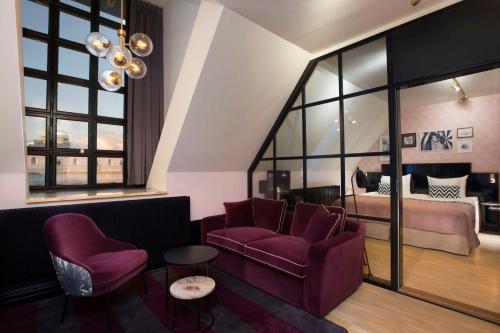 斯德哥尔摩斯堪达干草市场酒店的客厅配有紫色椅子和1张床