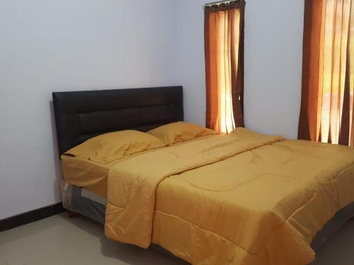 庞越Homestay Aisyah Bromo的一间卧室配有一张黄色棉被的床