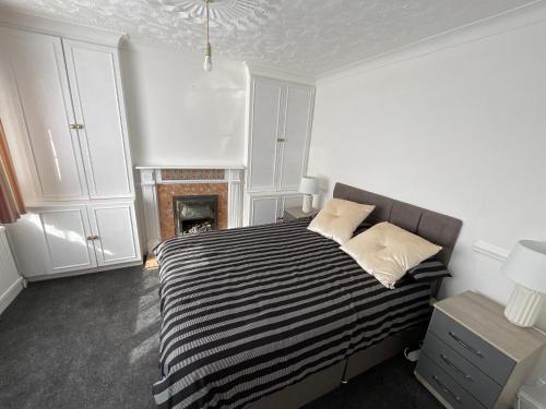 罗切斯特Stunning 4-Bed House in Rochester的卧室配有黑白床和壁炉