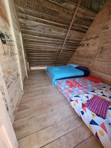 兰金Pachamaya Hostel的客房铺有木地板,配有两张床。