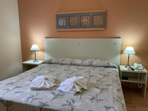 雷孔基斯塔HOTEL LOS TILOS RECONQUISTA的一间卧室配有一张床,上面有两条毛巾