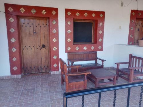 帕茨库卡罗Hotel Cabañas Chalamu的一间带椅子、电视和门的房间