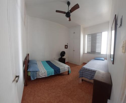 里约热内卢QUARTO EM COPACABANA的一间卧室配有两张床和吊扇