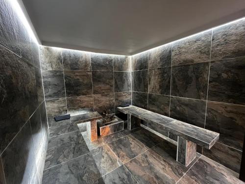 梅尔加Hotel Restaurante Versalles的浴室设有1张位于瓷砖墙壁上的长凳