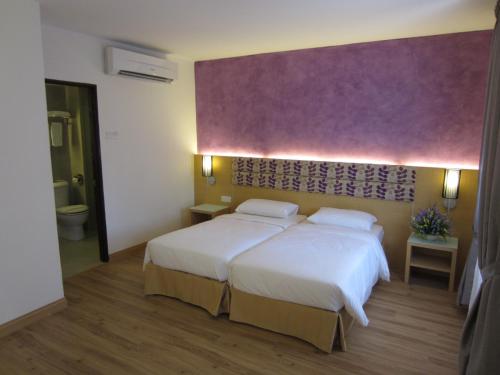 瓜埠Bella Vista Waterfront Resort, Kuah Langkawi的一间卧室设有两张床和紫色墙壁