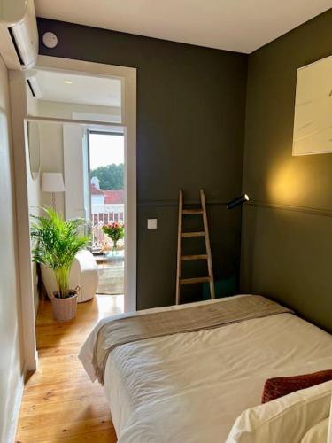 里斯本Stylish City Apartment - Top Stay!的一间卧室,配有梯子和一张位于房间的床