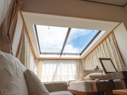 石垣岛cottage SOUL MATE的一间卧室设有大窗户和沙发