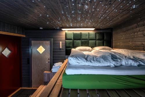 赫尔辛基Kalle's unluxury guest house Aircon 15min city center by train的一间卧室配有一张大床和绿色床头板