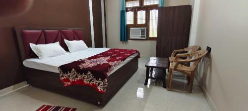 AyodhyaOYO Home Anandi Homestay的卧室配有床、椅子和窗户。
