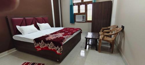AyodhyaOYO Home Anandi Homestay的一间卧室配有一张床和一把椅子