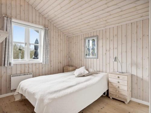 海默特Holiday home Hemmet VI的卧室配有白色的床和窗户。
