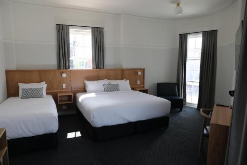 MortdaleMortdale Hotel的酒店客房,配有两张床和椅子