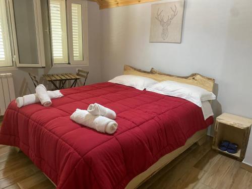 泰斯Bujtina Tinari Theth的一间卧室配有红色的床和毛巾