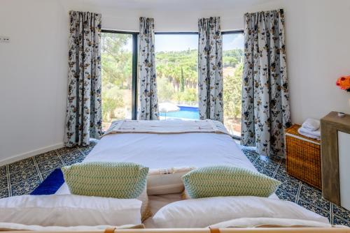 韦尔都勒博Casa dos Sonhos的一间卧室设有一张床和一个大窗户
