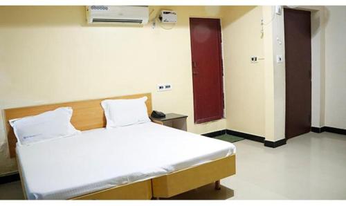 马杜赖FabExpress Sivabhagya Annex的一间医院房间,配有床和红色的门