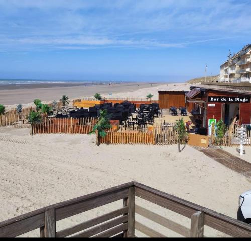 马翁普拉日堡Studio DUNES de NALA avec balcon vue Dunes et latérale Mer pour 4 pers 100m plage wifi ménage compris的享有海滩美景,设有围栏和餐厅。