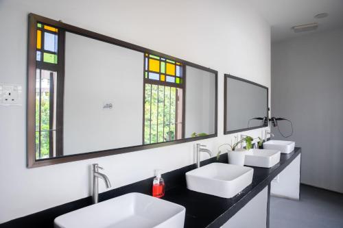 马六甲Sleep Here Hostel, Melaka的浴室设有2个水槽和2面镜子