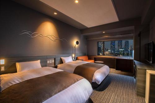 东京La Vista Tokyo Bay的酒店客房设有两张床和窗户。