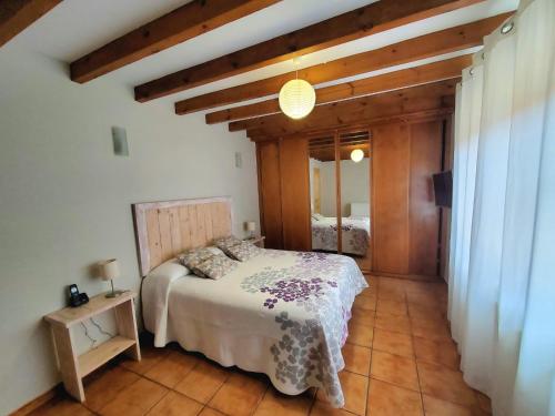 圣维森特-德拉巴尔克拉La Panera的一间带一张床的卧室,位于带木制天花板的房间内