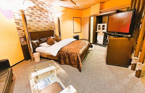 仙台Surfrider Adult Only的配有一张床和一台平面电视的酒店客房