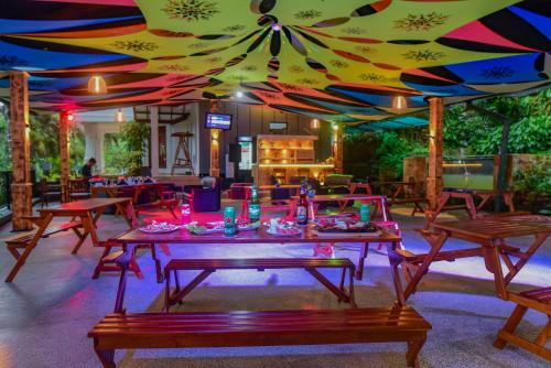 马特莱Siyonra Bungalow的餐厅拥有色彩缤纷的天花板,配有桌椅