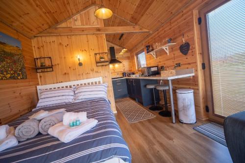 霍利黑德Beautiful Log Cabin with hot tub的小木屋内一间卧室,配有一张床