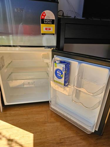 珀斯Private guest suite的装有牛奶盒的开放式冰箱