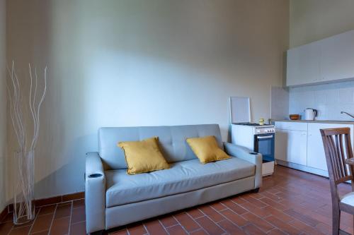 蒙托波利因瓦尔达尔诺Residence Montevecchio的厨房里配有带两个黄色枕头的蓝色沙发