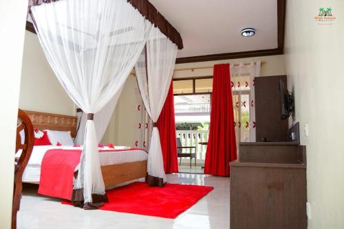 TezoWhite Peacock Resort的一间卧室配有一张红色地毯的天蓬床