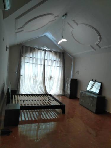 科托努Villa meublé的一个空房间,有床和窗户