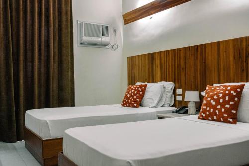 宿务蔡酒店及公寓的酒店客房设有两张床和窗户。